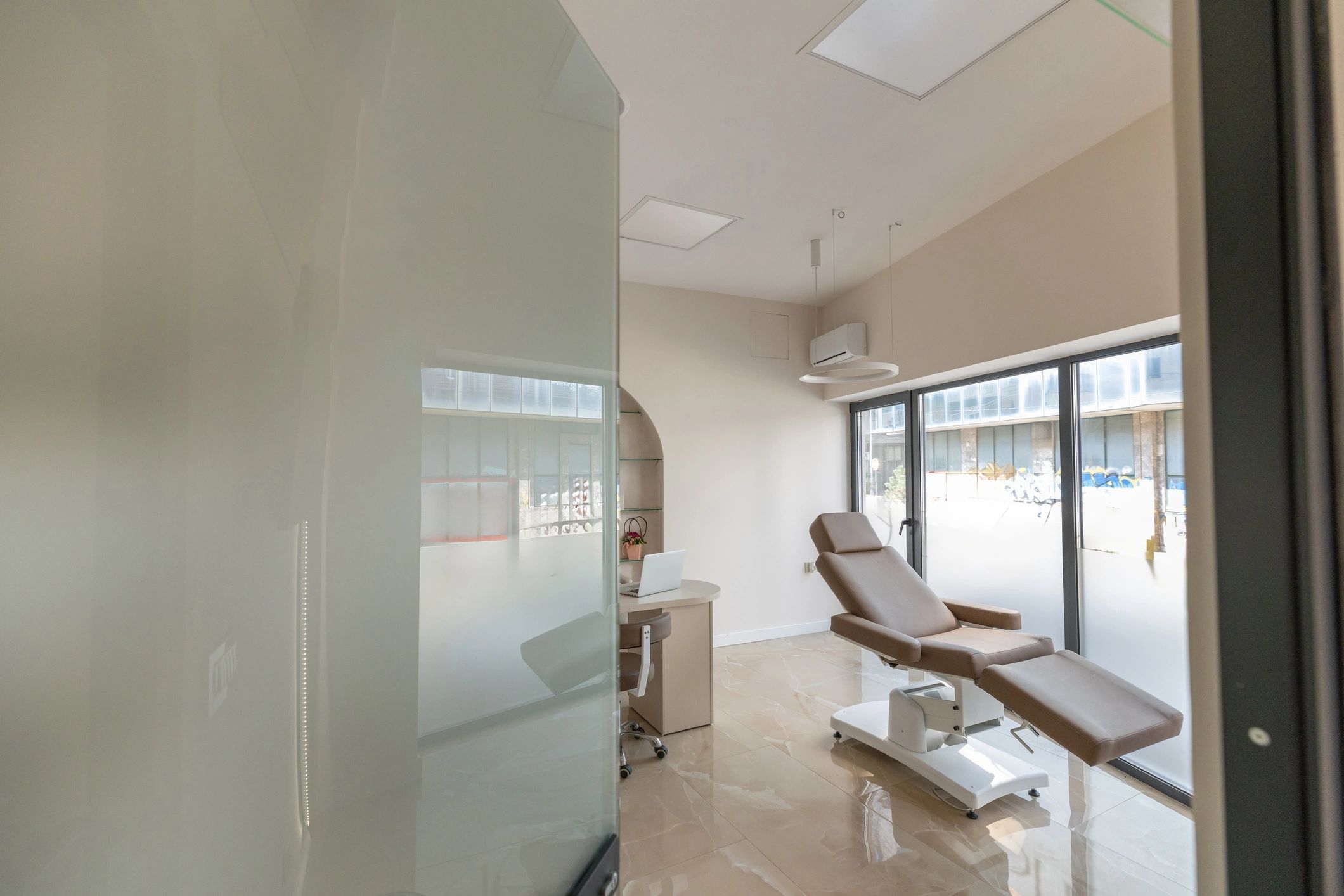 Clean, modern clinic interior with treatment bed and bright lighting